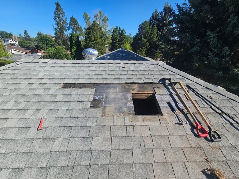 Residential roof with open ventilation hole and repair tools during construction work